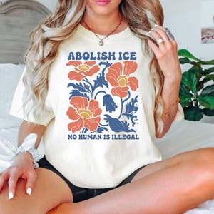 a woman sitting on top of a bed wearing a white shirt
