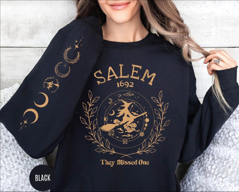 A woman wearing a black sweatshirt with a graphic design on it.