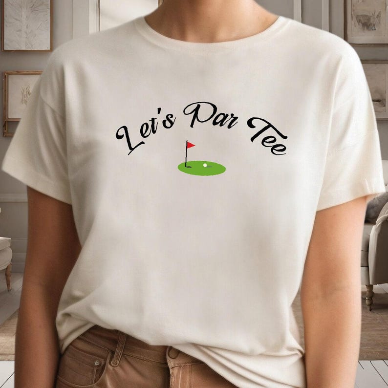 a woman wearing a white shirt with a green golf ball on it