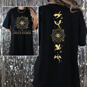 a woman wearing a black shirt with gold designs on it