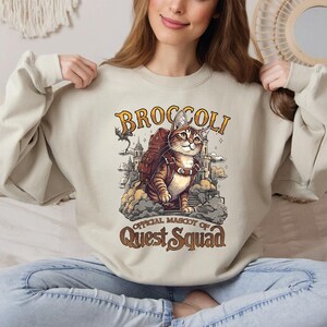 a woman sitting on a bed holding a sweatshirt