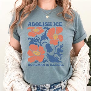 a woman wearing a blue shirt with orange flowers on it
