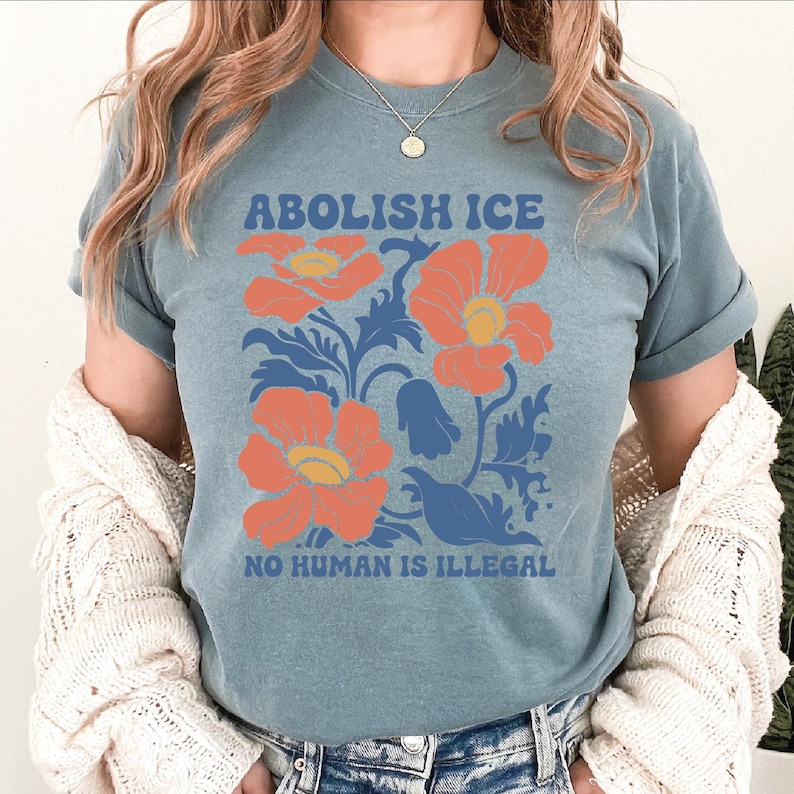 a woman wearing a blue shirt with orange flowers on it