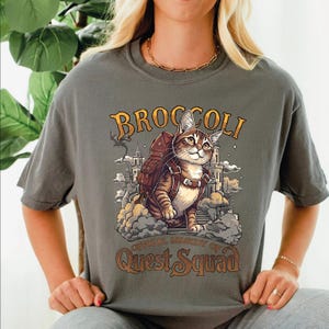 a woman wearing a broccoli t - shirt with a cat on it
