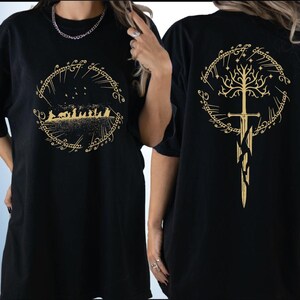 two black t-shirts with gold designs on the back. The designs include a tree with a sword and a group of people, likely referencing the Lord of the Rings series.