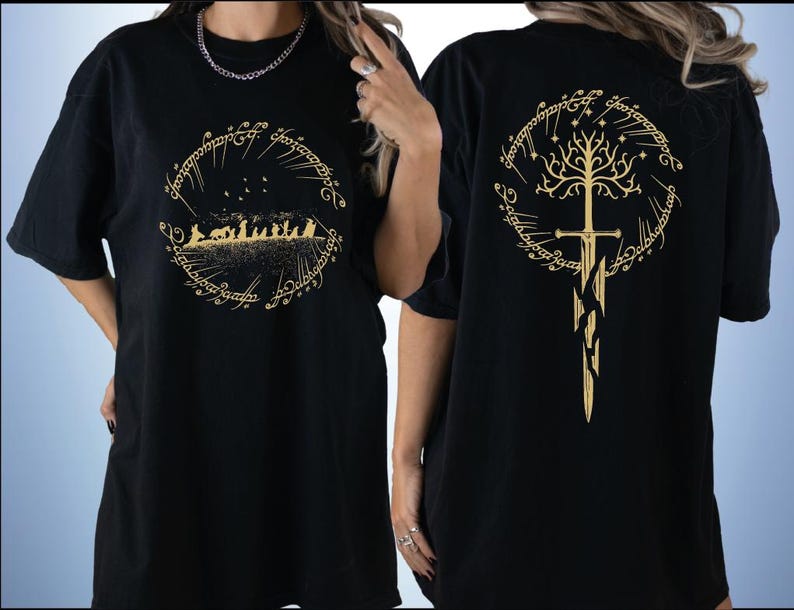 two black t-shirts with gold designs on the back. The designs include a tree with a sword and a group of people, likely referencing the Lord of the Rings series.