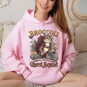 a woman wearing a pink hoodie with a cat on it