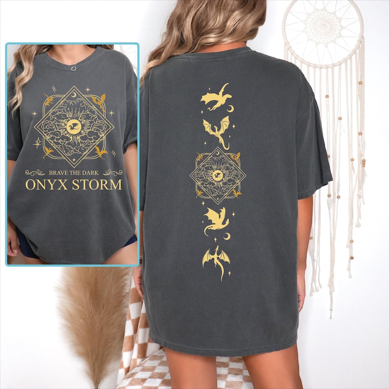 a woman wearing a black shirt with gold designs on it