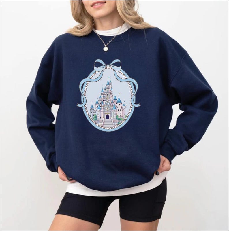 A woman wearing a navy blue sweatshirt with a graphic of a castle on it.