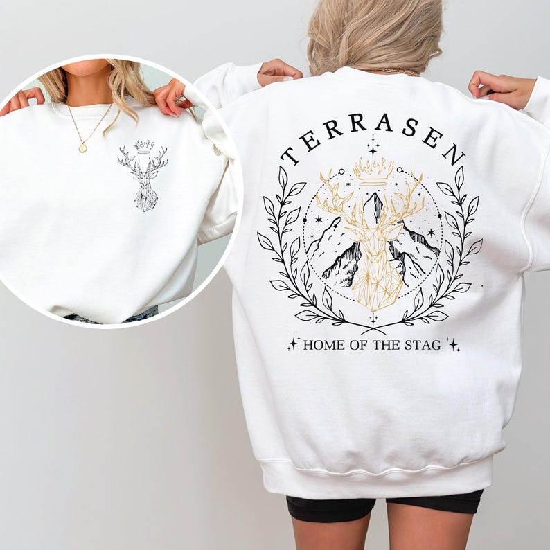 A woman wearing a white sweatshirt with a graphic design on the back.