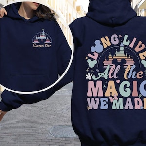 A person wearing a navy blue hoodie with a colorful graphic design on the back.