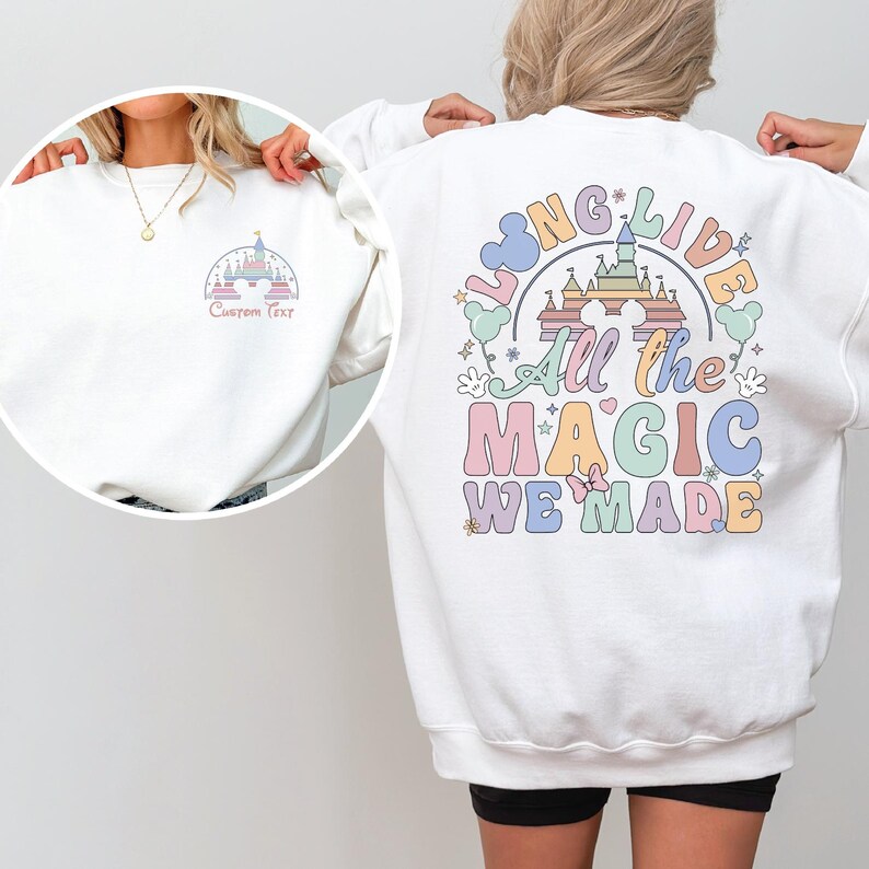 A person wearing a white sweatshirt with a colorful graphic design on the back.