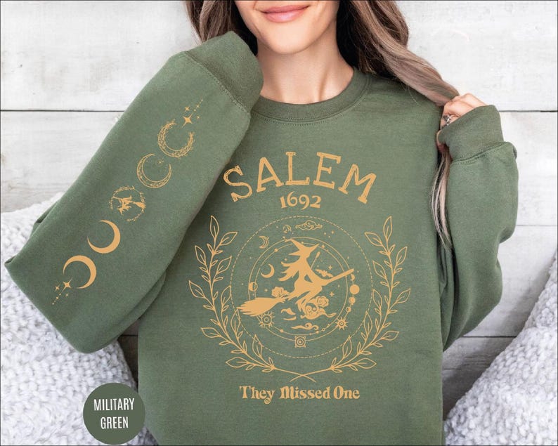 A woman wearing a green sweatshirt with a graphic design on it.