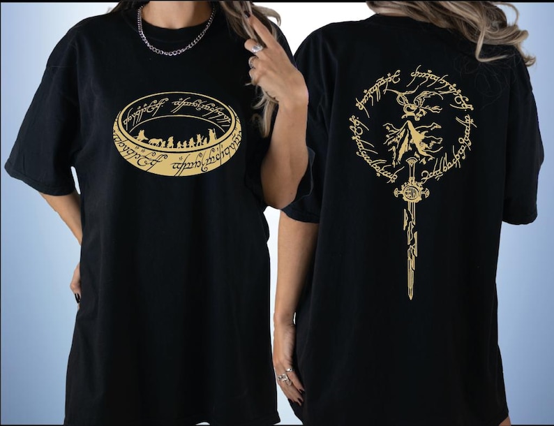 two black t-shirts with gold designs on the back. The design on the left features a circular emblem with a silhouette of a group of people, while the design on the right depicts a winged figure with a sword.