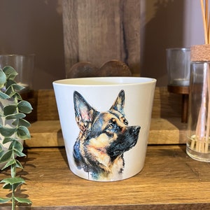 Op de afbeelding: Witte keramische mok met een aquarel-illustratie van een Duitse herder die naar rechts kijkt. De hond is bruin, zwart en beige.