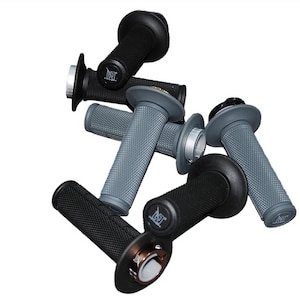 Puede incluir: Primer plano de cinco puños de motocicleta. Los puños son negros y grises con una superficie texturizada. Los puños tienen un logotipo que dice "NST".