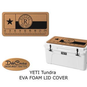 K&ouml;nnte beinhalten: Wei&szlig;er YETI Tundra-K&uuml;hler mit einer individuellen EVA-Schaumstoff-Deckelauflage. Die Deckelauflage ist braun mit einem schwarzen Streifen, einem Stern und dem Text "ROGERS Est. 2025". Ein Lineal ist am unteren Rand aufgedruckt. Der Text "Dek Covers" ist ebenfalls sichtbar.