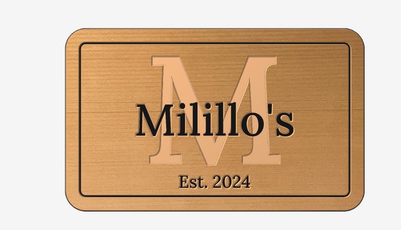 May include: A wooden sign with a raised, gold-colored letter "M" and the text "Milillo's Est. 2024".