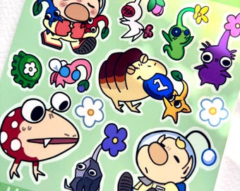 Könnte beinhalten: Ein Stickerbogen mit verschiedenen Zeichentrickfiguren aus der Pikmin-Serie, darunter kleine pflanzenartige Wesen mit Blumen, eine große rot-weiß gepunktete Kreatur und zwei Weltraumforscher in gelben Anzügen auf einem hellgrünen Hintergrund.