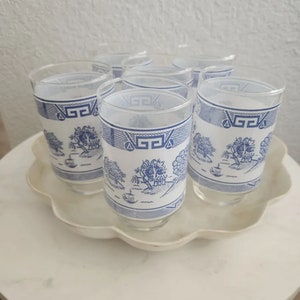 May include: Set of six blue and white glass drinking glasses with a traditional Chinese design. The glasses have a frosted finish and are perfect for serving water, juice, or iced tea.
