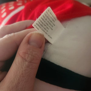 May include: White tag with black text listing the materials used to make the plush toy. The tag reads "All new material Polyester fiber, Polyethylene foam Reg. No. PA-6525(HK) Made in China, Putian KiuHung-CNPT-0820 For ages 3 and up Surface clean only. Air dry &copy; Disney"