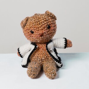 愛らしいぬいぐるみのヒグマ。黒と白のカーディガンを着たかわいいぬいぐるみ動物