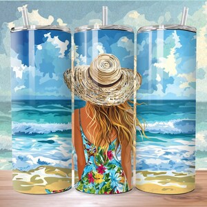 May include: Three stainless steel tumblers with a beach scene design. The design features a woman with long blonde hair wearing a straw hat and a floral dress, looking out at the ocean. The ocean is blue and green with white waves. The sand is yellow and the sky is blue with white clouds.