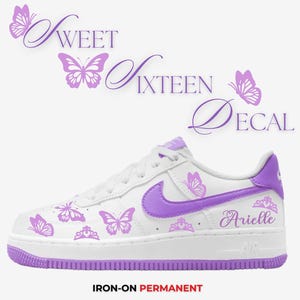 May include: White and purple Air Force 1 sneakers with butterfly and crown decals. The text "Sweet Sixteen Decal" is above the shoe. The name "Arielle" is on the side of the shoe. The words "Iron-on Permanent" are at the bottom.