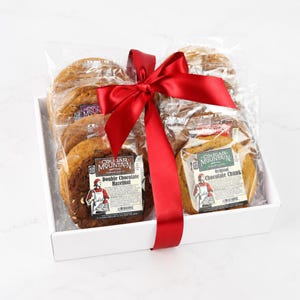 May include: A white gift box containing multiple individually wrapped cookies, including Double Chocolate Hazelnut and Original Chocolate Chunk varieties, tied with a large, bright red satin ribbon across the center.