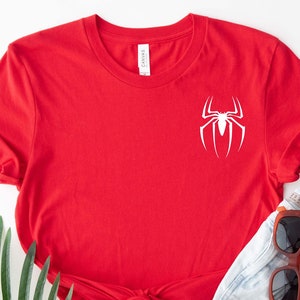 May include: Red short-sleeved t-shirt with a white spider graphic on the front.