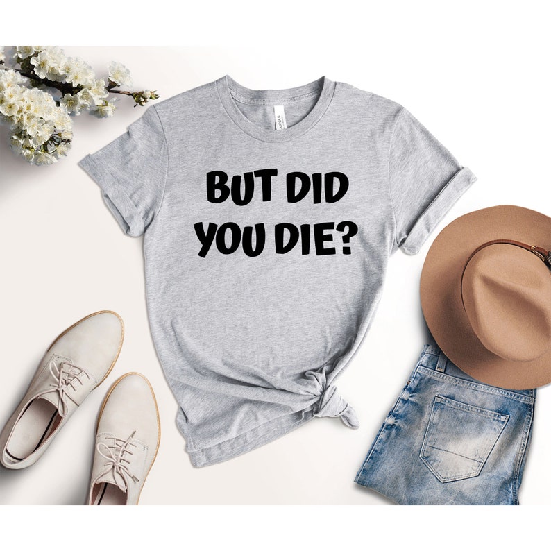 May include: Gray t-shirt with black text that reads "But Did You Die?"