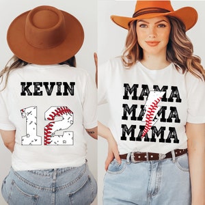 以下が含まれることがあります： 野球をテーマにしたデザインの白いTシャツ2枚。1枚は「Kevin」という名前と「12」という数字に野球のグラフィックが描かれている。もう1枚は「Mama」という単語が稲妻と野球のグラフィックと共に3回繰り返されている。