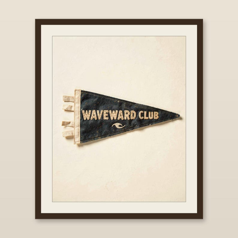 Waveward Club vintage felt surf pennant printable displayed in a warm wood frame on a softly lit neutral wall