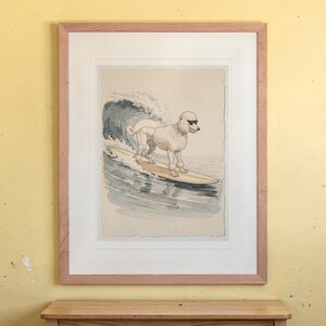 Poodle Surfing print in a Red Oak frame with a white mat, hanging above the desk in a kids' room.