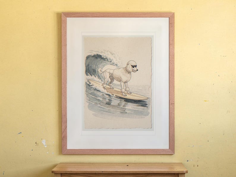 Poodle Surfing print in a Red Oak frame with a white mat, hanging above the desk in a kids' room.