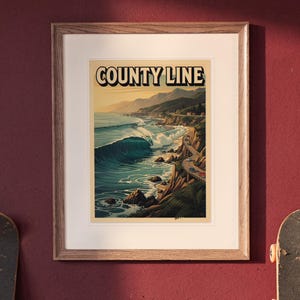 County Line Surf Travel Poster print in a Red Oak frame with a white mat, hanging above the desk in a green study.