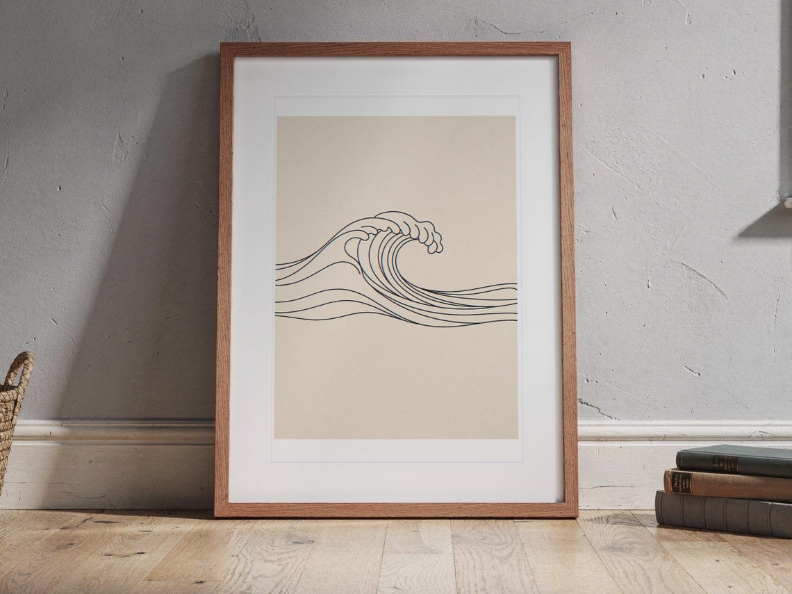 Breaking Wave Line print in a Red Oak frame with a white mat, standing on the floor, leaning back slightly against the wall in a living room floor lean.