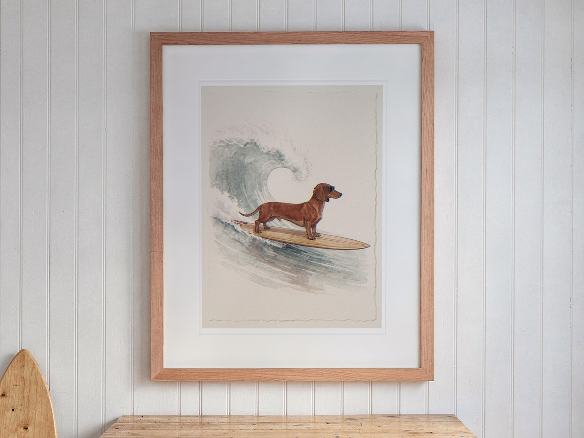 Dachshund Surfing print in a Red Oak frame with a white mat, hanging above the desk in a kids' room.