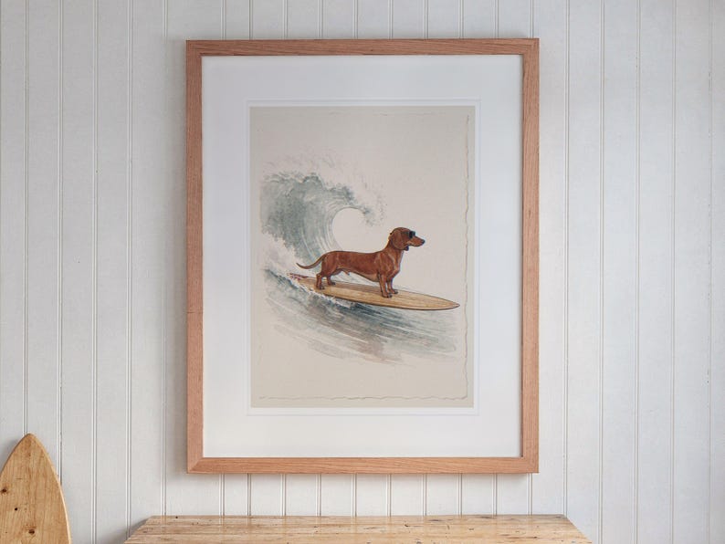Dachshund Surfing print in a Red Oak frame with a white mat, hanging above the desk in a kids' room.
