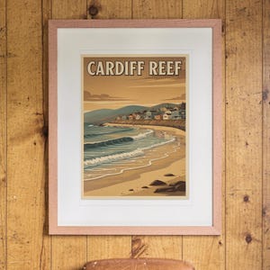 Cardiff Reef Surf Travel Poster print in a Red Oak frame with a white mat, hanging on the paneling in a 1960s den.