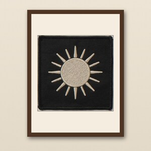 Sun Embroidered Patch Print - walnut framed art print with cream mat on plaster wall