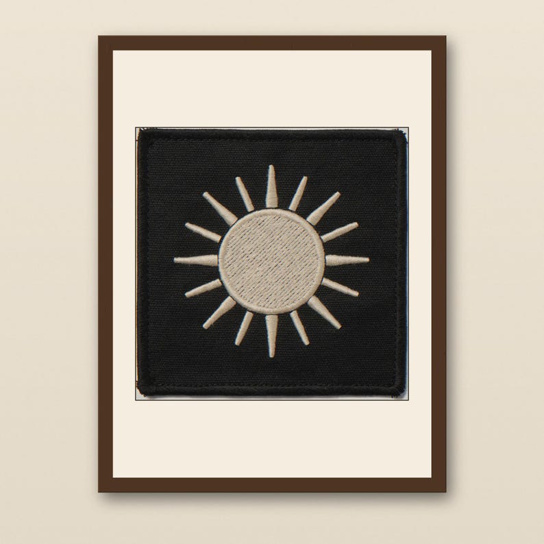 Sun Embroidered Patch Print - walnut framed art print with cream mat on plaster wall