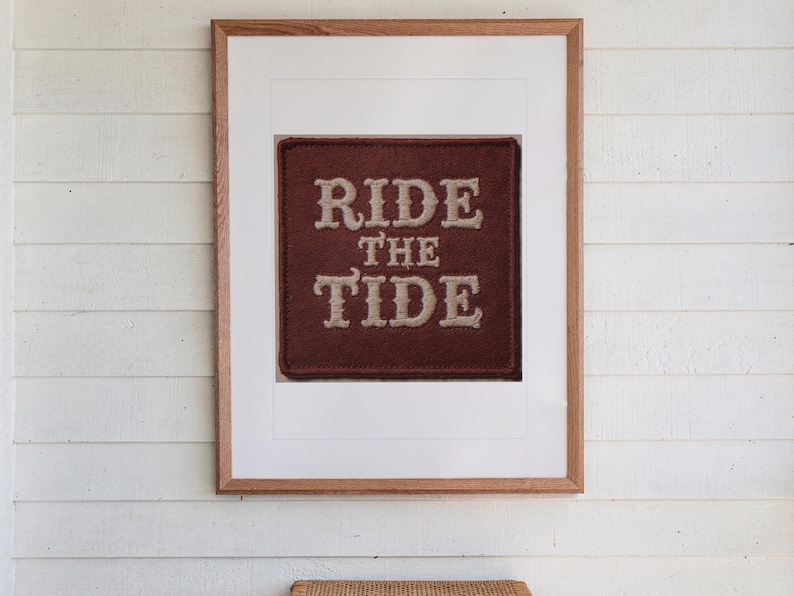 Ride the Tide Patch print in a Red Oak frame with a white mat, hanging above the table in a screened beach porch.