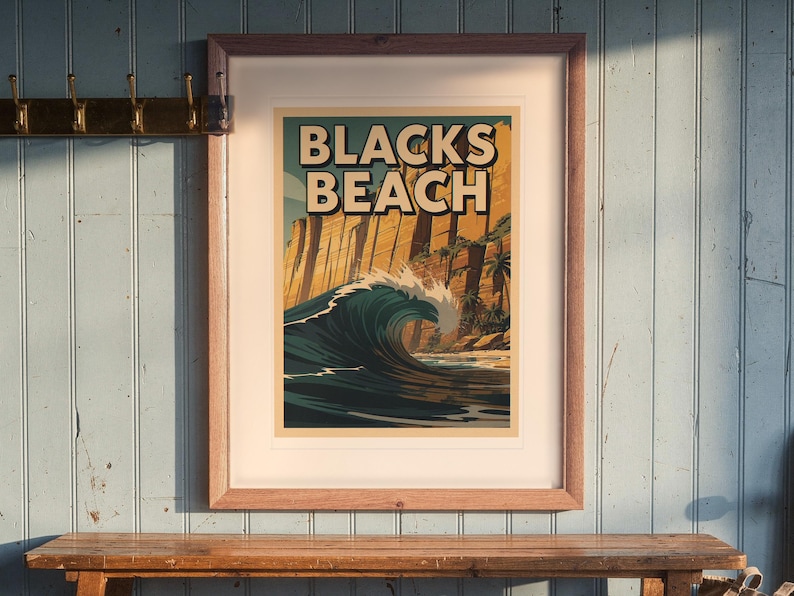 Blacks Beach Surf Travel Poster print in a Red Oak frame with a white mat, hanging above the bench in a beach cottage entryway.
