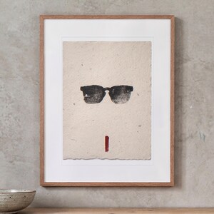 Sunglasses Ink Style print in a Red Oak frame with a white mat, hanging above the console in a japandi living room.