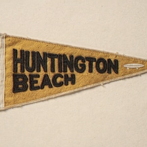 Huntington Beach Vintage Surf Pennant Print framed in a coastal dining room setting