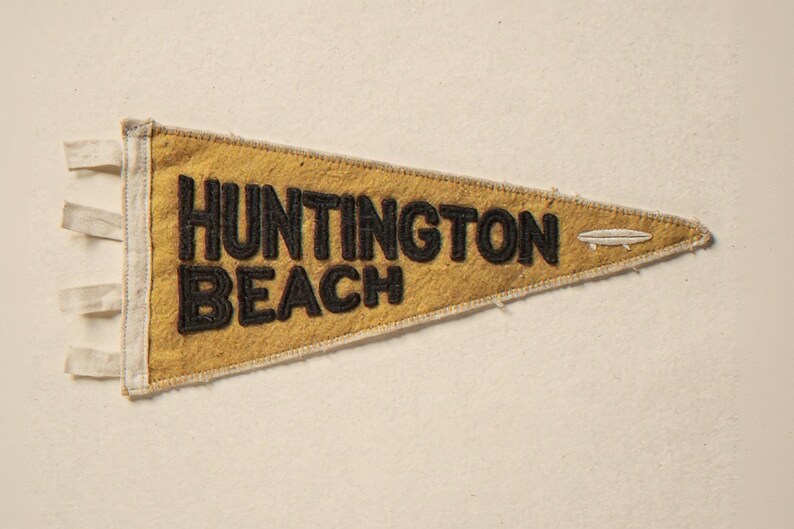 Huntington Beach Vintage Surf Pennant Print framed in a coastal dining room setting