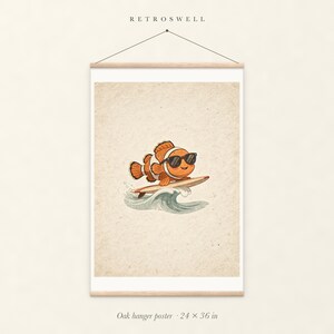 Surfing Clownfish oak hanger poster, 24 by 36 inches, with natural wood rails and a hanging cord.