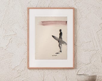 Puede incluir: Una lámina de arte enmarcada que muestra la silueta oscura de una persona sosteniendo una tabla de surf sobre un fondo beige claro. Un trazo de pincel horizontal de color rojo oscuro aparece en la parte superior. El marco es de madera clara.