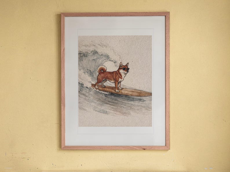 Shiba Inu Surfing print in a Red Oak frame with a white mat, hanging above the bookshelf in a kids' room.